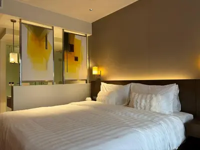 a bedroom with a large bed with white sheets and pillows at The Hotel Residences at Acqua in Manila