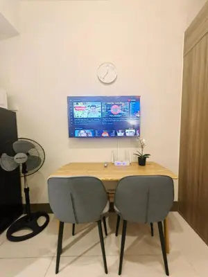 a dining room table with two chairs and a clock on the wall at 1BR Condotel with Balcony at FAME Residences #FM37-1 in Manila