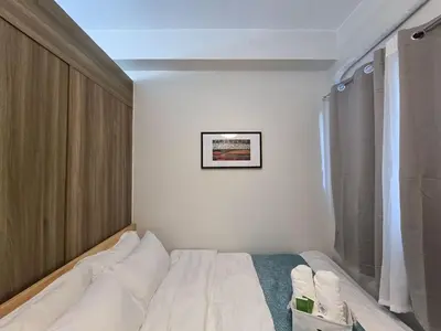 a bedroom with a bed and a picture on the wall at 1BR Condotel with Balcony at FAME Residences #FM38-1 in Manila
