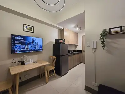 a kitchen with a table and a refrigerator at 1BR Condotel with Balcony at FAME Residences #FM38-1 in Manila