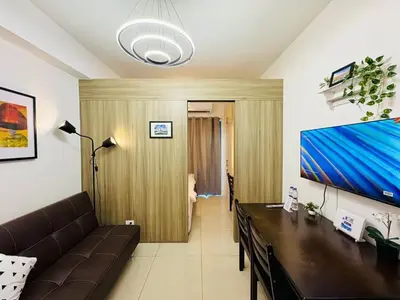 a living room with a couch and a flat screen tv at 1BR Condotel with Balcony at FAME Residences #FM42-1 in Manila