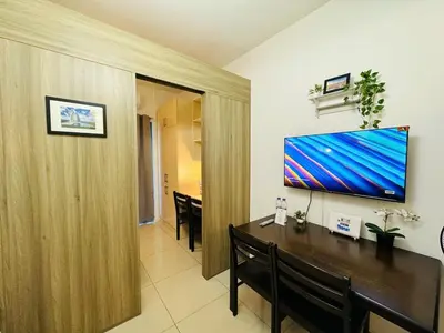 a living room with a television on a wall at 1BR Condotel with Balcony at FAME Residences #FM42-1 in Manila