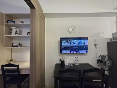 a dining room with a table and a tv on the wall at 1BR Condotel with Balcony at FAME Residences #FM43-1 in Manila
