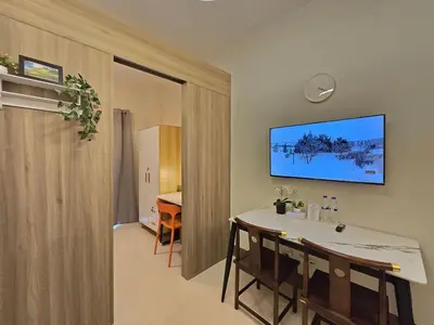 a dining room with a table and a television on the wall at 1BR Condotel with Balcony at FAME Residences #FM44-1 in Manila