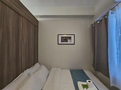 a bedroom with a bed and a picture on the wall at 1BR Condotel with Balcony at FAME Residences #FM45-1 in Manila