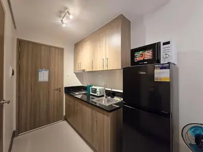 a kitchen with a black refrigerator and a sink at 1BR Condotel with Balcony at FAME Residences #FM46-1 in Manila