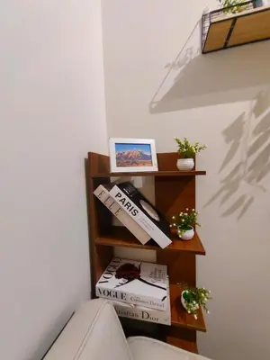 a book shelf in a corner with books at 1BR Condotel with Balcony at FAME Residences #FM51-1 in Manila