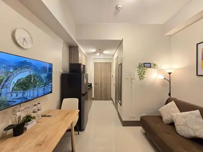 a living room with a couch and a table at 1BR Condotel with Balcony at FAME Residences #FM48-1 in Manila