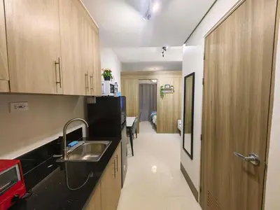 a kitchen with wooden cabinets and a sink at 1BR Condotel with Balcony at FAME Residences #FM52-1 in Manila