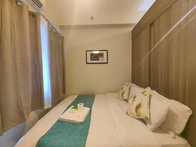 a small bedroom with a bed with a scale on it at 1BR Condotel with Balcony at FAME Residences #FM52-1 in Manila