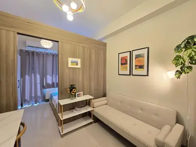 a living room with a couch and a bed at 1BR Condotel with Balcony at FAME Residences #FM54-1 in Manila