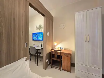 a bedroom with a desk and a table with a chair at 1BR Condotel with Balcony at FAME Residences #FM56-1 in Manila