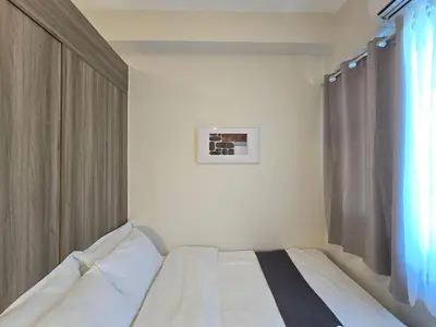 a white bed in a room with a window at 1BR Condotel with Balcony at FAME Residences #FM57-1 in Manila