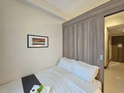 a bedroom with a white bed with a picture on the wall at 1BR Condotel with Balcony at FAME Residences #FM59-1 in Manila