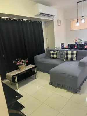 a living room with couches and a black curtain at Lumiere Residences in Manila