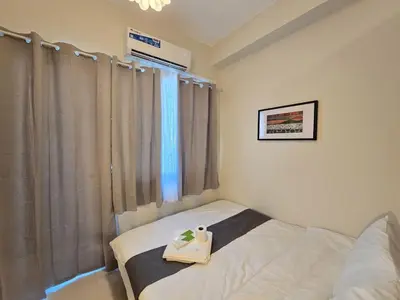 a bedroom with a bed with a tray on it at 1BR Condotel with Balcony at FAME Residences #FM61-1 in Manila
