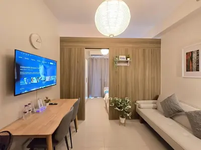 a living room with a table and a couch at 1BR Condotel with Balcony at FAME Residences #FM64-1 in Manila