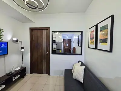a living room with a couch and a mirror at 1BR Condotel Ridgewood Towers Near Airport #RW02-1 in Manila