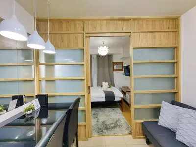 a bedroom with a bed and a room with shelves at 1BR Condotel Ridgewood Towers Near Airport #RW03-1 in Manila