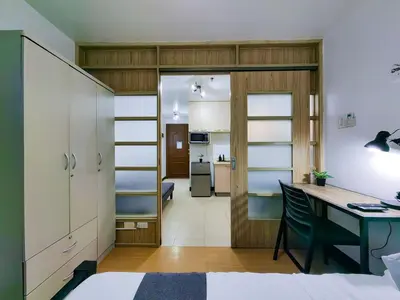 a room with a desk and a bedroom at 1BR Condotel Ridgewood Towers Near Airport #RW04-1 in Manila