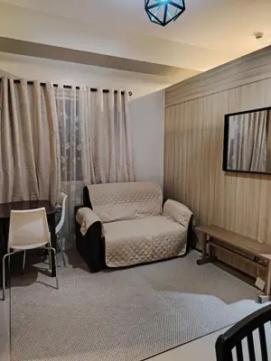 a bedroom with a bed and a table and a desk at Zenys Staycation at Shore 1 Residences in Manila