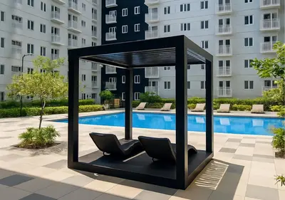 a black chair sitting next to a swimming pool at Relax Condotel in Manila