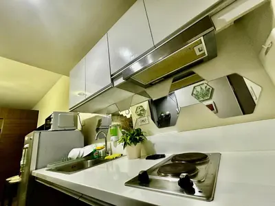 a small kitchen with a sink and a stove at MyScape at Air Residences Makati in Manila