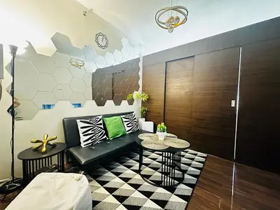 a living room with a couch and a table at MyScape at Air Residences Makati in Manila