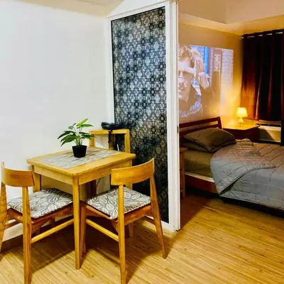 a room with a table and chairs and a bed at Casa Kalma - Beach View Staycation in Manila