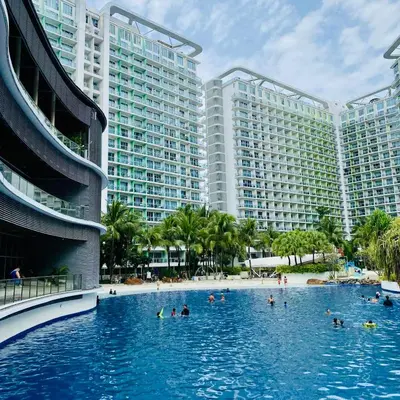 a swimming pool in front of two large buildings at Casa Kalma - Beach View Staycation in Manila