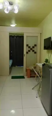 a living room with a table and a tv at Ladybugs Condotel SR in Manila