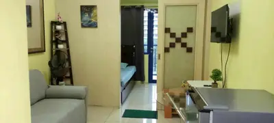 a living room with a couch and a tv in it at Ladybugs Condotel SR in Manila