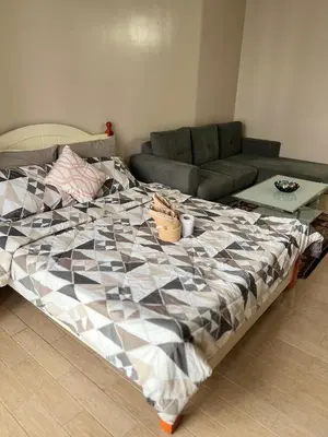 a large bed in a living room with a couch at L&D Condominium in Manila