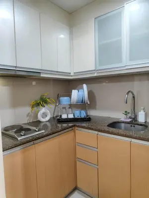 a kitchen with white cabinets and a sink at L&D Condominium in Manila