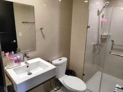 a bathroom with a toilet and a sink and a shower at L&D Condominium in Manila