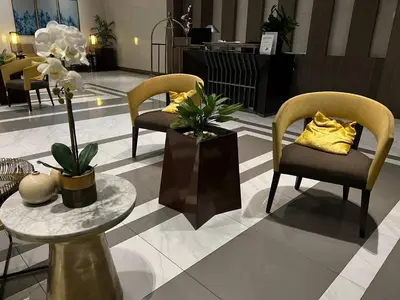 a lobby with two chairs and a table with flowers at L&D Condominium in Manila