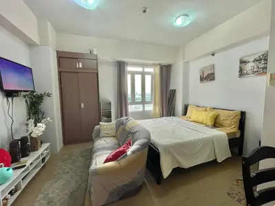 a living room with a bed and a couch at Rose150newportpasay in Manila