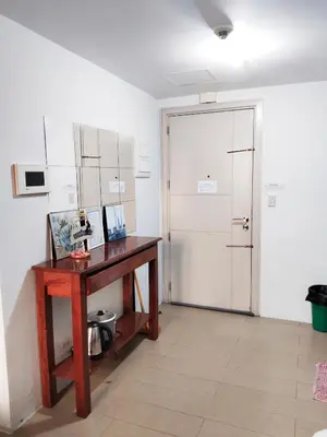 a room with a wooden desk and a door at Rose150newportpasay in Manila