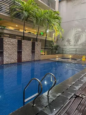 a swimming pool with a bench in a building at JennieRosecondo150newportpasay in Manila