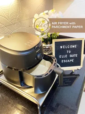 an air fryer with parchment paper on a counter with a sign at Modern Unit at Shore 2 Mall of Asia by Elle Suite in Manila