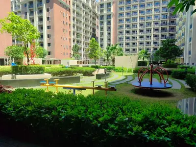 a playground in the middle of a city with tall buildings at Condo near Moa with Pool Access WS1205 in Manila
