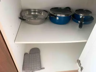 a shelf with pots and pans in a kitchen at Avant at the Fort 360 City Center views in BGC Taguig w Pool Access in Manila