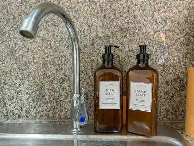 two bottles of alcohol sitting on a kitchen sink at 2bedroom Loft Apartment within BGC in Manila