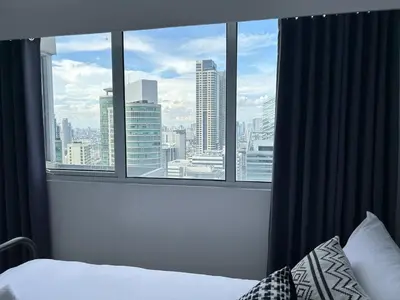 a bedroom with a view of a city from a window at 2bedroom Loft Apartment within BGC in Manila