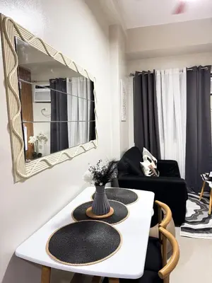 a living room with a table and a mirror at Nap & Go Staycation in Manila