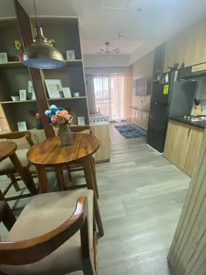 a kitchen and dining room with a table with flowers on it at Propitious Place at Sta Mesa in Manila