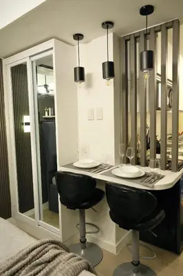 a kitchen with a counter with chairs and mirrors at SM Bicutan Getaway in Manila