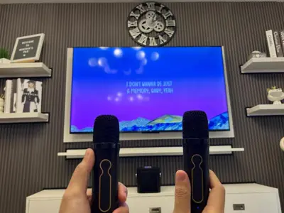a person holding up a wii remote in front of a tv at SM Bicutan Getaway in Manila