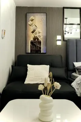 a living room with a black couch and a table at SM Bicutan Getaway in Manila