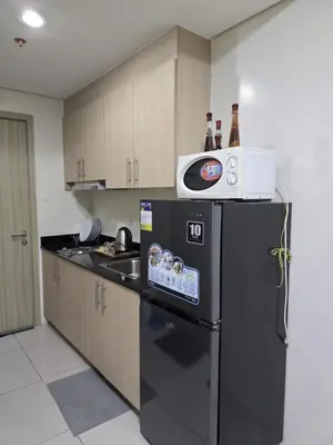 a kitchen with a black refrigerator and a microwave at Rhoydez Condotel Breeze Residence in Manila
